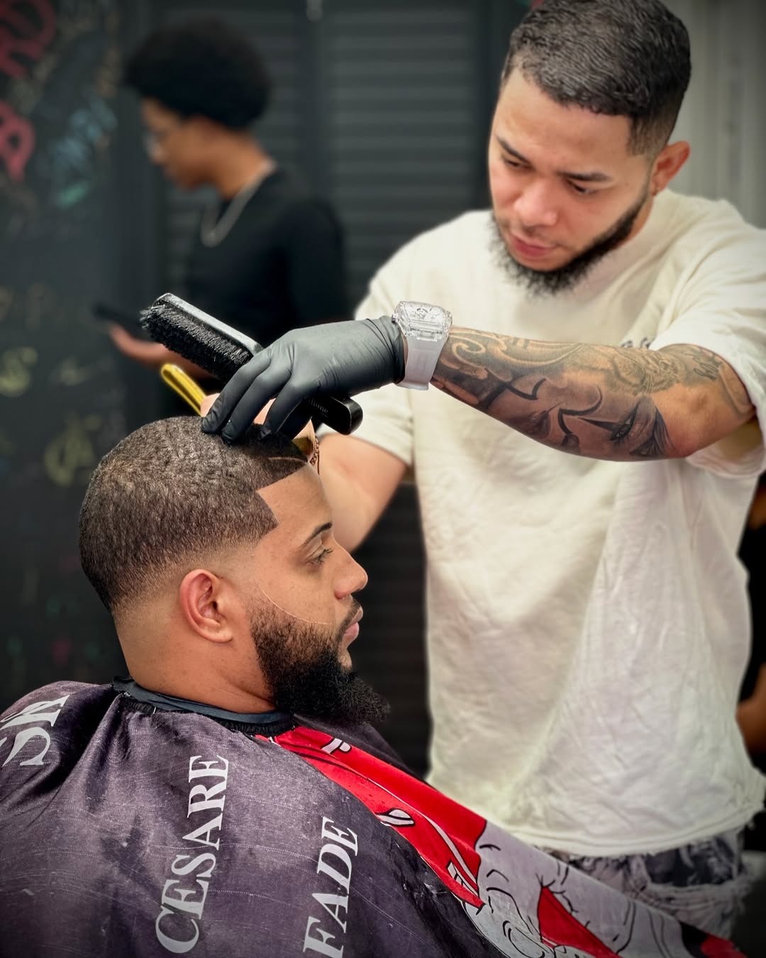 Barber detailing a haircut with a brush at Authentic Cutz